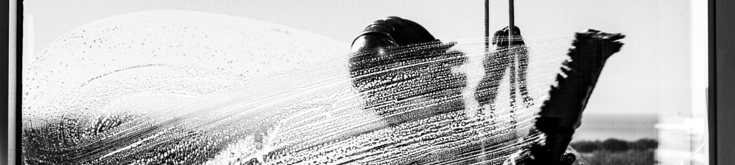 Hand cleaning glass with cloth during coating application