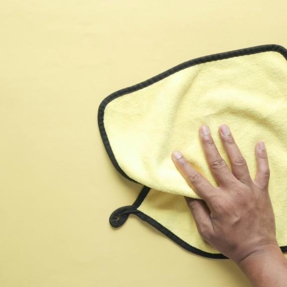 Een oppervlak wordt schoongemaakt met een microvezeldoek voor een streeploos en hygienisch resultaat. (Slide 4 van 5)